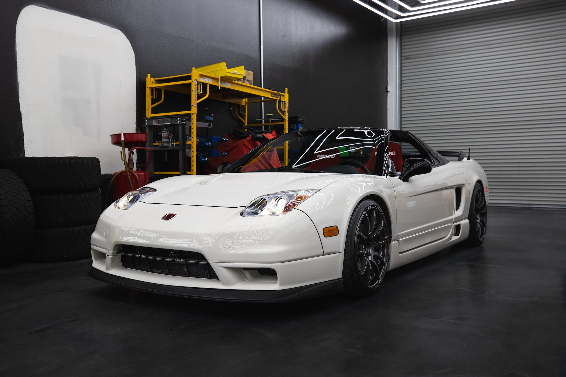 a white convertible car parked in a garage