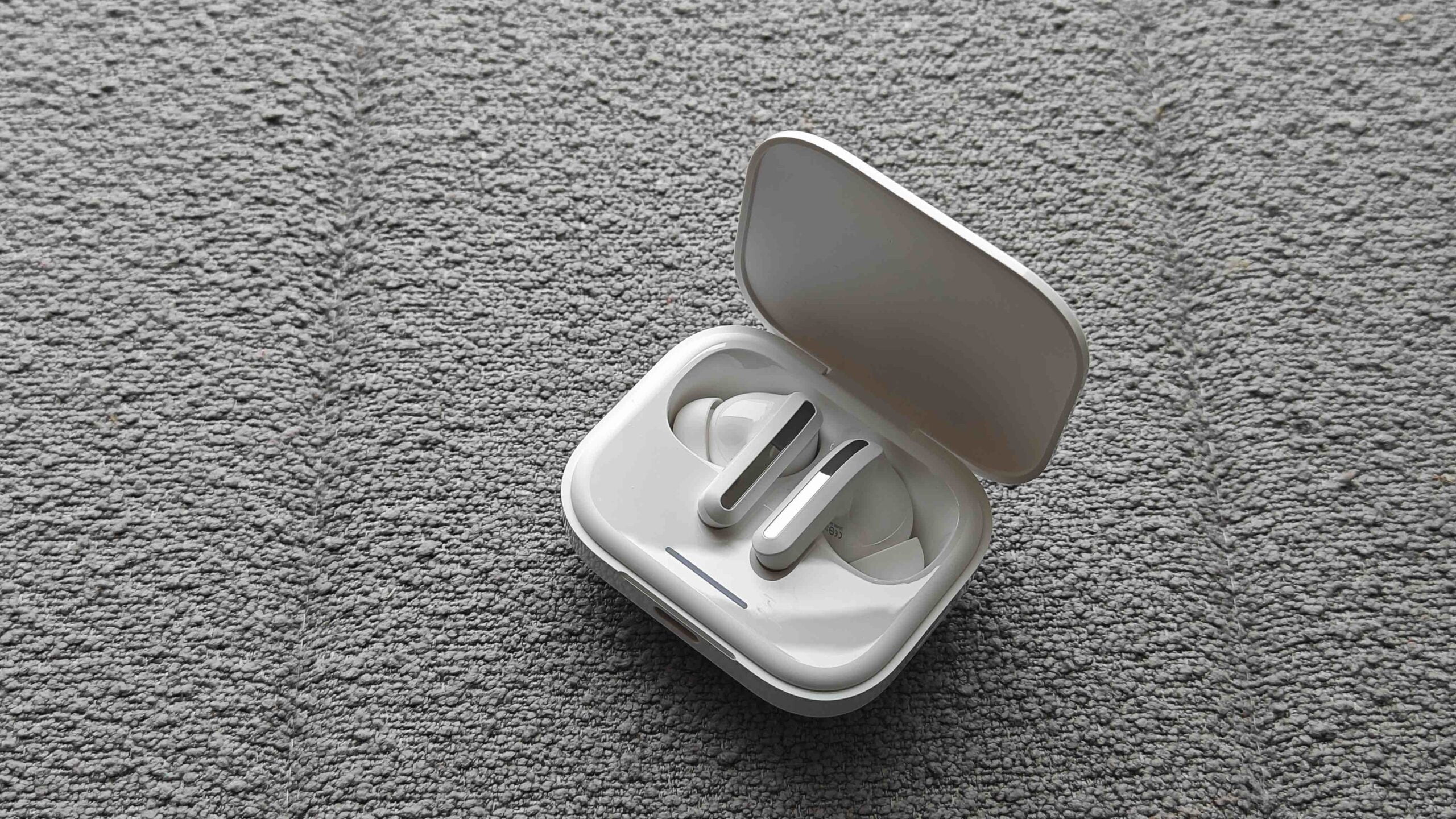 打開充電盒,一對白色帶柄耳機