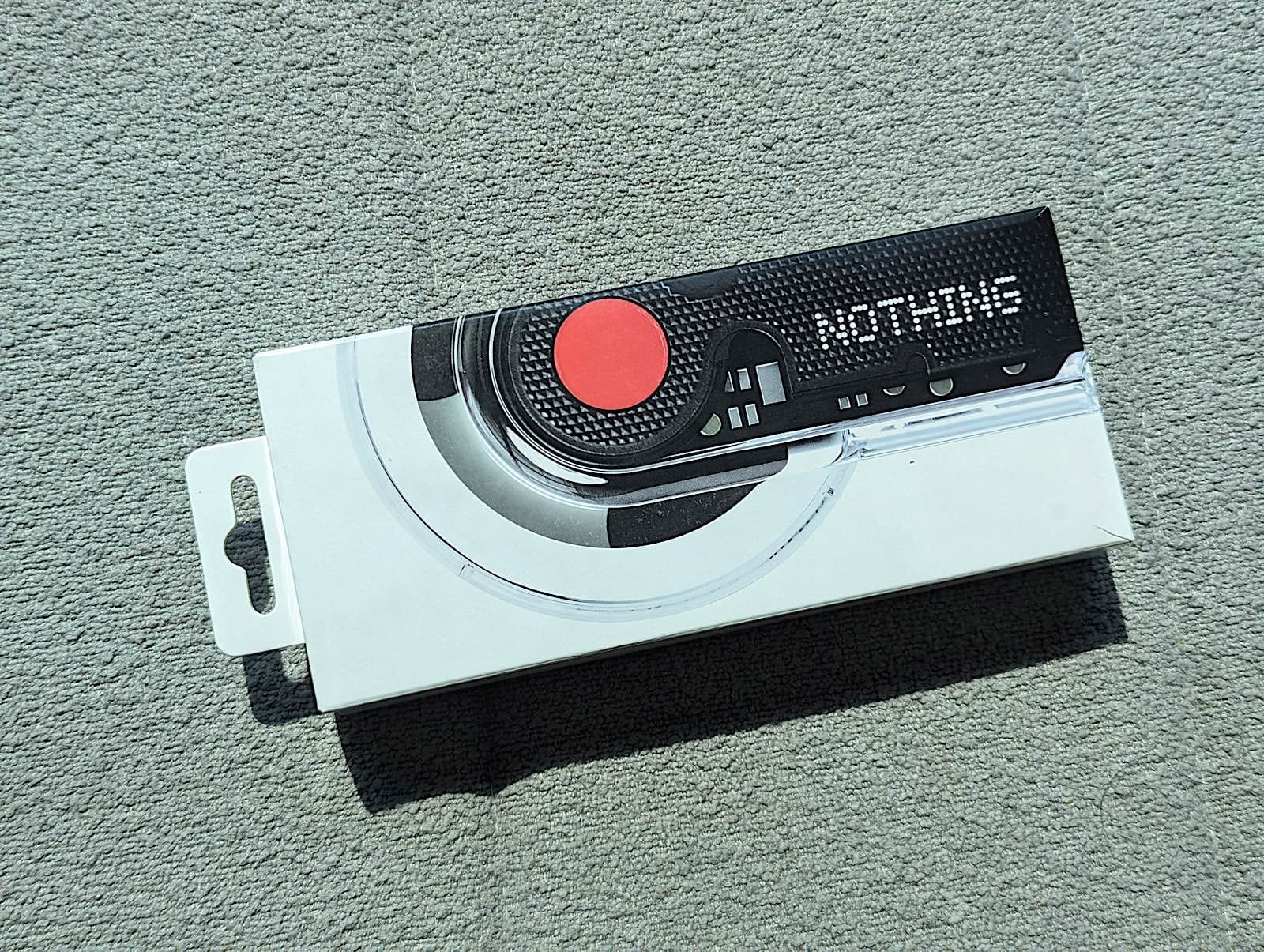 小売パッケージ、黒いドットで「NOTHING」の文字と赤い点