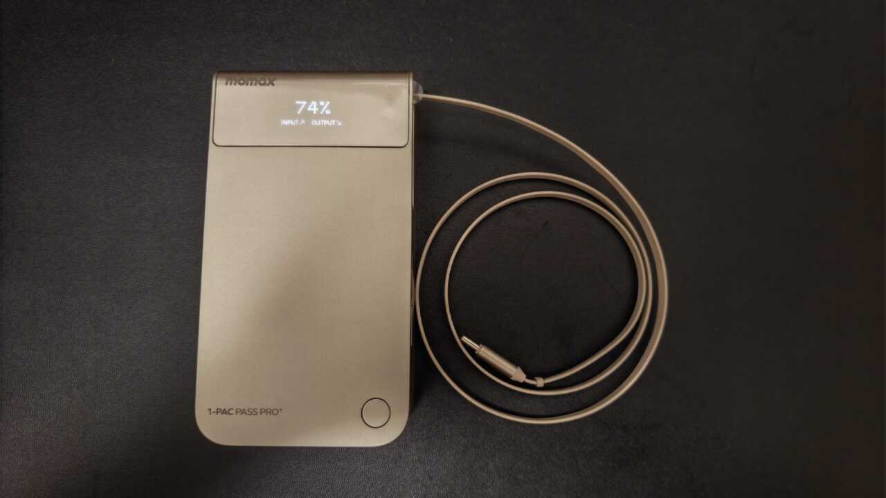 MOMAX 1-Pac Pass Pro+ - シャンパンゴールドのボディに内蔵伸縮 USB-C ケーブル、前面 TFT スクリーンが 74% と入力/出力方向を表示