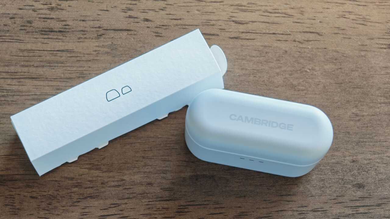 白色充電盒與印有耳塞圖案的配件紙盒,盒蓋印有 CAMBRIDGE 字樣。