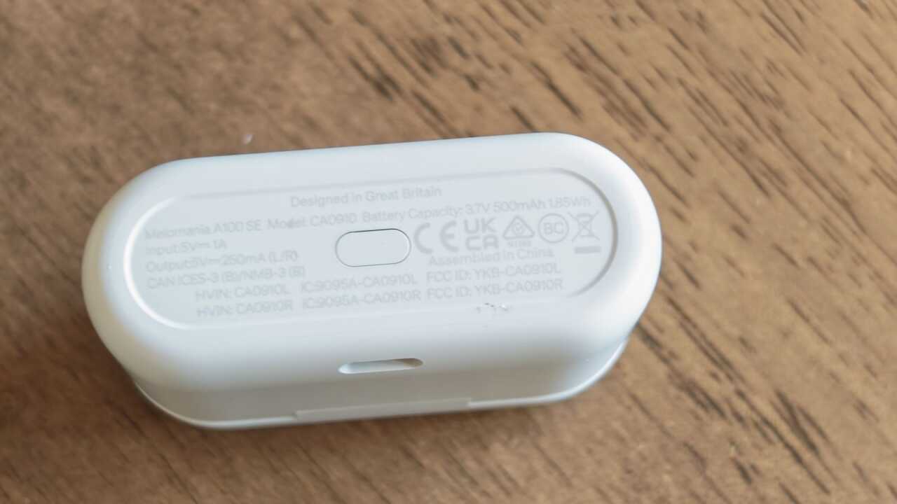 充電盒底部印有型號及電池資料,中間可見橢圓形按鍵。