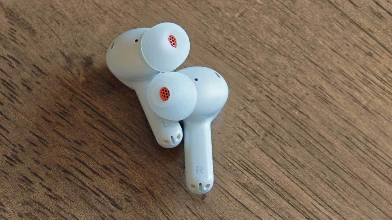 耳機內側可見 L/R 標記、耳柄末端金色接點,以及耳塞中央的橙色網面。