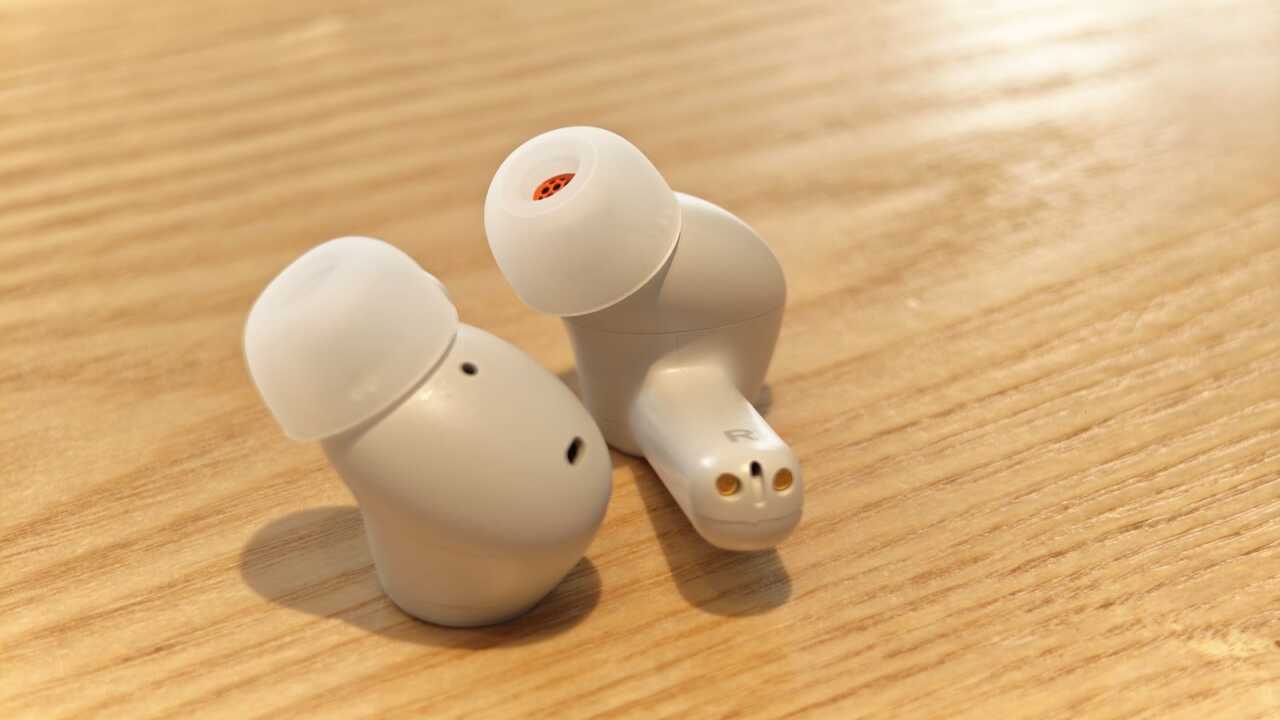 白色 A100 SE 耳機實物近照,展示矽膠耳塞、外殼開孔及耳柄末端接點(並非 app 截圖)。